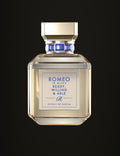 Ready, Willing & Able, extrait de parfum Romeo is Alive : flacon en verre transparent, jus champagne clair, bouchon doré, bague sertie de pierres bleues et plaque dorée gravée en bleu